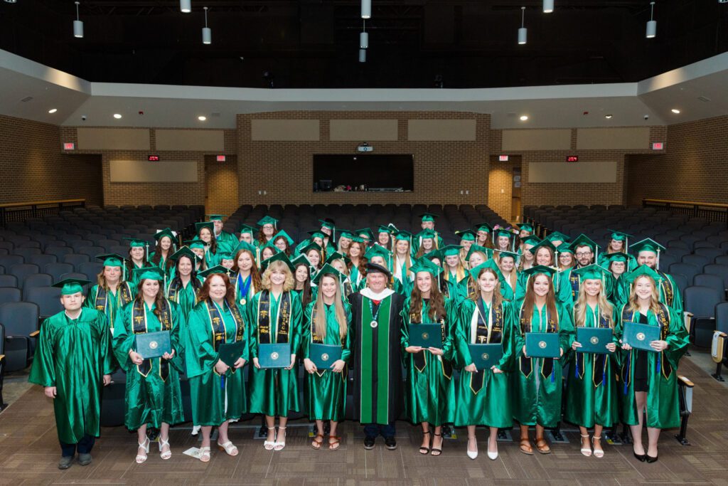 Photo of 2026 Eastern graduates with President of college.